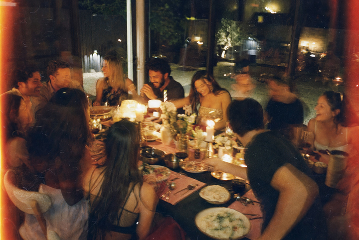 Guests sharing food around a warm candlelit table